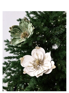 Detail of velvet magnolia Christmas flowers with glitter edges on a festive tree branch