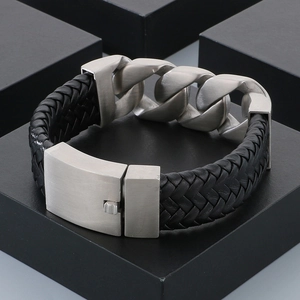 Close-up of men's leather bracelet with silver Cuban link chain and magnetic buckle