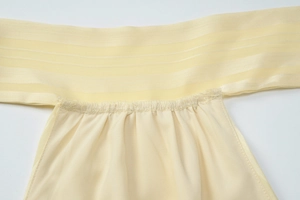 Detail of light yellow ribbed fabric featuring delicate shirred texture and elastic seam