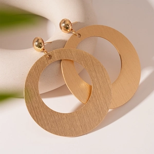 Exaggerated golden geometric hoop earrings with brushed metal finish for a bold look