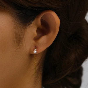 Detailed close-up of S925 silver long tassel pearl earring on model with gold finish