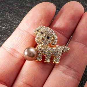 Cute puppy brooch with sparkling rhinestones and a large brown pearl held in hand
