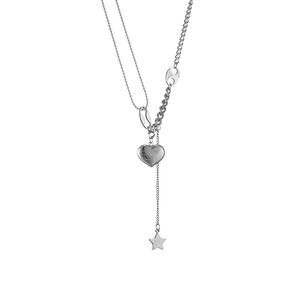 Close-up of silver necklace featuring heart and star pendants with mixed chain textures