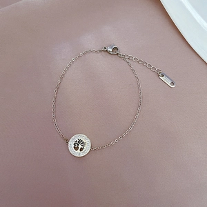 Detailed shot of golden tree of life charm bracelet with sparkling zircon pavé on steel