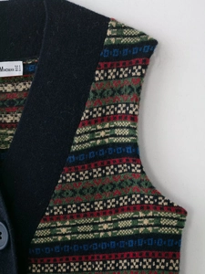 Dettaglio del gilet in maglia Fair Isle con scollo a V e etichetta della taglia S