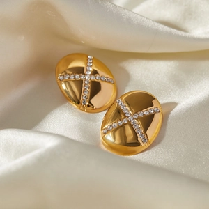 Detail of 18k gold plated teardrop earrings featuring a crystal cross inlay on silk