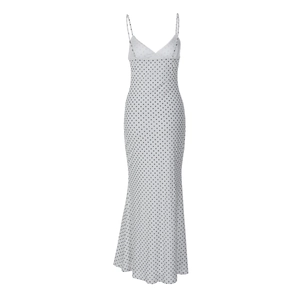 Detail view of the deep V-neckline and elegant polka dot pattern on the white dress