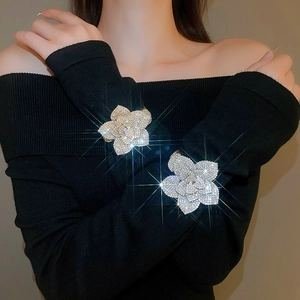Close-up of adjustable silver flower bracelets with zircon inlay on a model wearing black