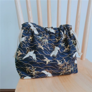 Détail d'un sac à bento japonais bleu foncé avec des motifs de grues et de vagues