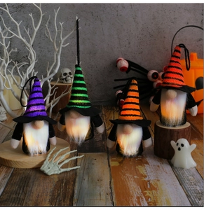 Detailed view of four glowing Halloween gnome ornaments with striped hats and spooky decor