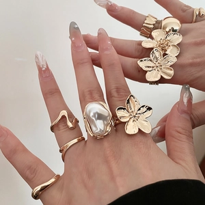 Close-up of gold flower pea ring set with irregular pearls on a hand model