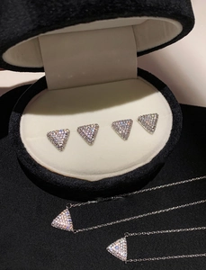 Detailed view of silver triangle necklace and earring set with shimmering cubic zirconia