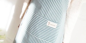 Detailed close-up of breathable cotton linen apron pocket with Ladle Fork logo label