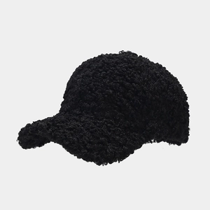 Detailed texture of black faux lamb wool fabric on a thick warm baseball cap