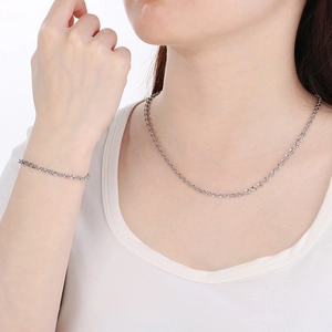 Polished stainless steel embossed chain necklace and bracelet set on a female model