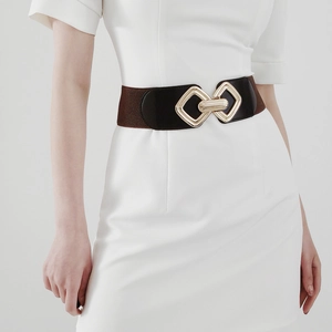 Détail d'une large ceinture élastique avec boucle géométrique dorée et bordure en cuir marron