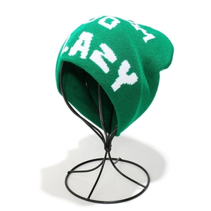 Detail of green knit beanie featuring white pixel-style LAZY jacquard lettering