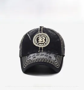 Detail of vintage washed black baseball cap with embroidered patch and lettered brim