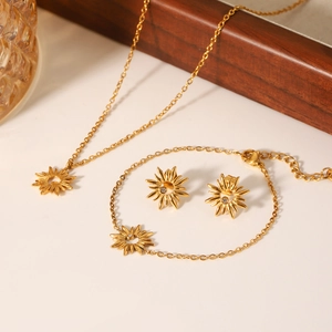 Golden stainless steel sunflower jewelry set with necklace and earrings on a tray