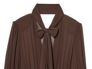 Detail eines dunkelbraunen Chiffonkleides mit großer Schleife und Schulterfalten
