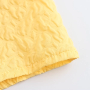 Close-up of yellow textured bubble embossed fabric detail on sweet style maxi dress