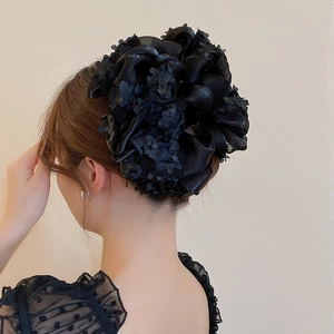 Détail d'une grande pince à cheveux noeud noir en maille d'organza sur les cheveux
