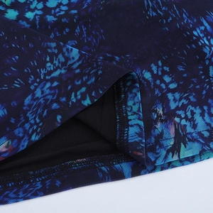 Detail view of the layered mesh fabric with abstract floral print and hemline stitching