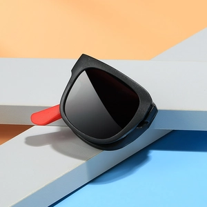 Foldable vintage square kids sunglasses with black frame and red tips on geometric background
