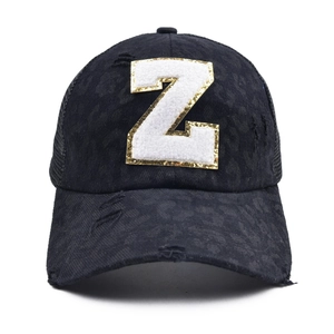 Close-up of black leopard print baseball cap featuring distressed fabric and a large 'Z' patch