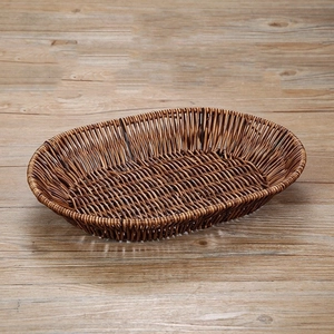Detail view of oval dark brown woven bread basket on a natural wooden tabletop surface