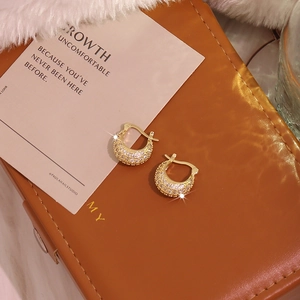 Luxurious 18K gold plated hoop earrings with micro-pave zircons on brown leather