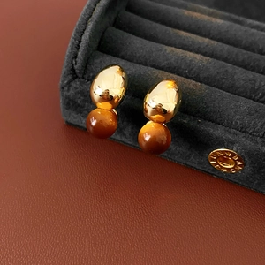 Macro detail of French vintage gold and brown faux tiger eye double bead stud earrings