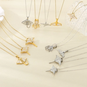 Detailansicht der gold- und silbernen Meeresanhänger mit Perlmutt- und Zirkon-Inlay