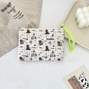 Detail view of quilted floral pouch with cute dog print and vibrant green zipper pull