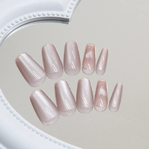 Champagne cat-eye press-on nails in medium ballet shape with elegant white heart patterns