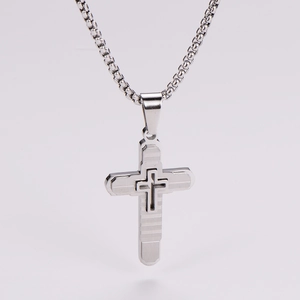 Close-up of silver stainless steel triple layer cross pendant with horizontal texture