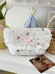 Détail du sac matelassé avec motif ours, dentelle blanche et nœud en satin rose