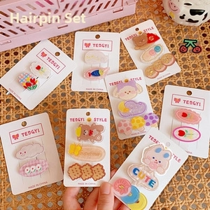 Close-up of cute cartoon acrylic hair clips with tulip and bear motifs on paper card