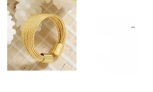 Detail of gold multilayer braided open ring on decorative white coral stone stand