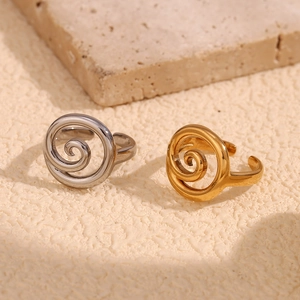 Macro shot of 18K gold and silver spiral twist open rings on natural stone texture
