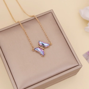 Close-up of golden butterfly necklace with blue-purple gradient crystal on jewelry box