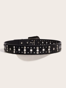 Detail of black faux leather belt with crocodile texture and silver butterfly buckle