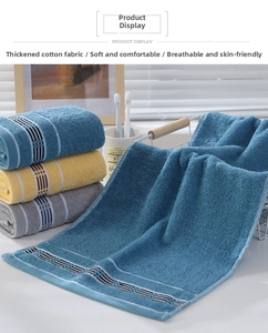 Detailed close-up of thick cotton towels with striped jacquard in blue, yellow, and grey