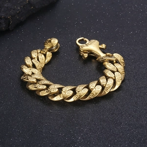 Close-up of gold Cuban link bracelet with engraved Egyptian hieroglyphs and symbols