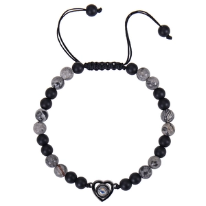 Detail of 6mm matte black and marble beads with heart projection pendant on a braided cord