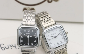 Detail of square quartz watches with black and white dials and silver steel mesh bands