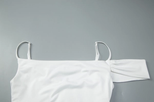 Detail of adjustable spaghetti straps and elegant off-shoulder neckline on a white dress