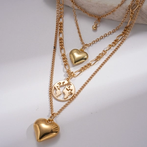 Detail of layered gold sweater chain featuring 3D heart and world map globe pendants