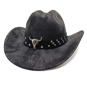 Detail of western cowboy hat featuring black leather band with silver bull skull ornament