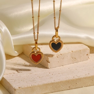 Détail des colliers à pendentif cœur rouge et noir sur un tissu de soie doux